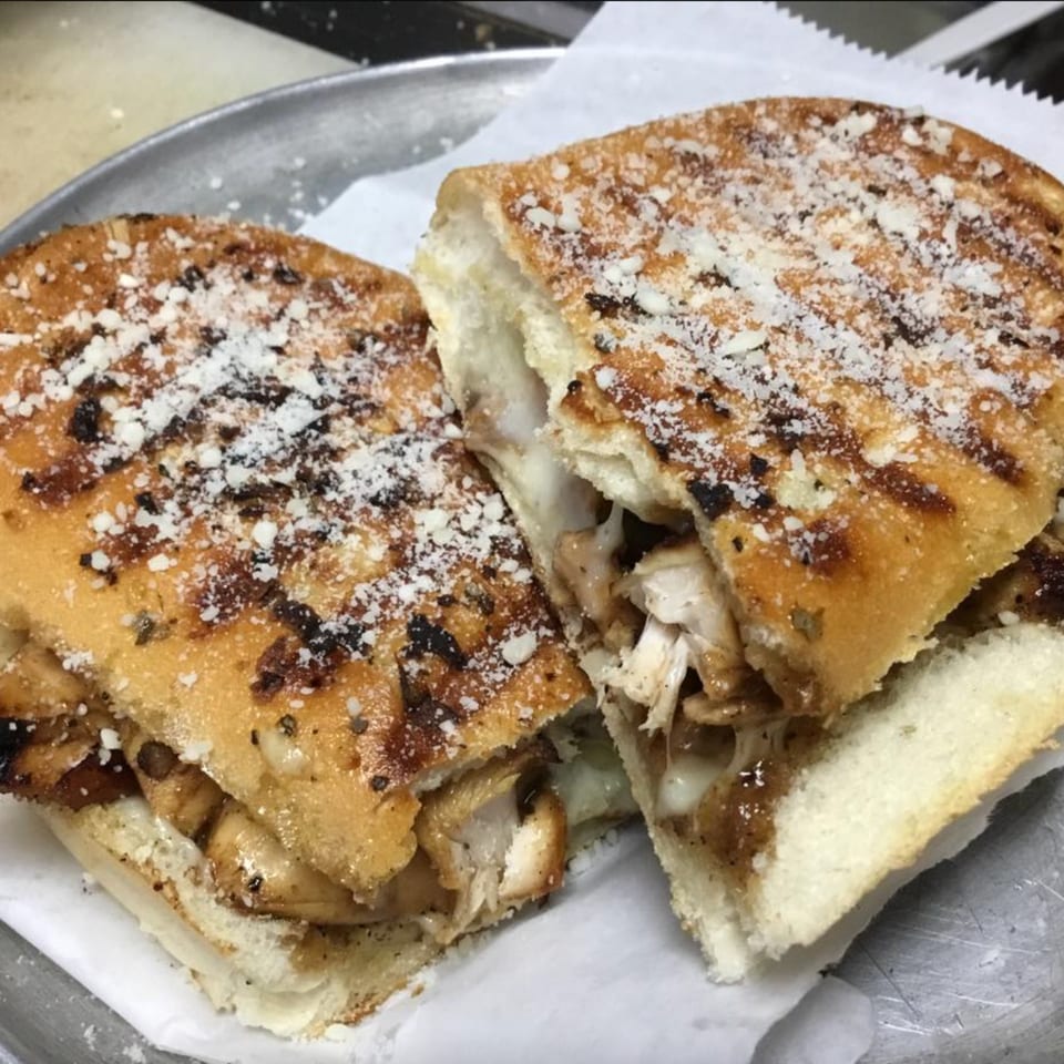 Grilled chicken and melted cheese sandwich on focaccia bread, dusted with Parmesan, from Vito's Bistro.