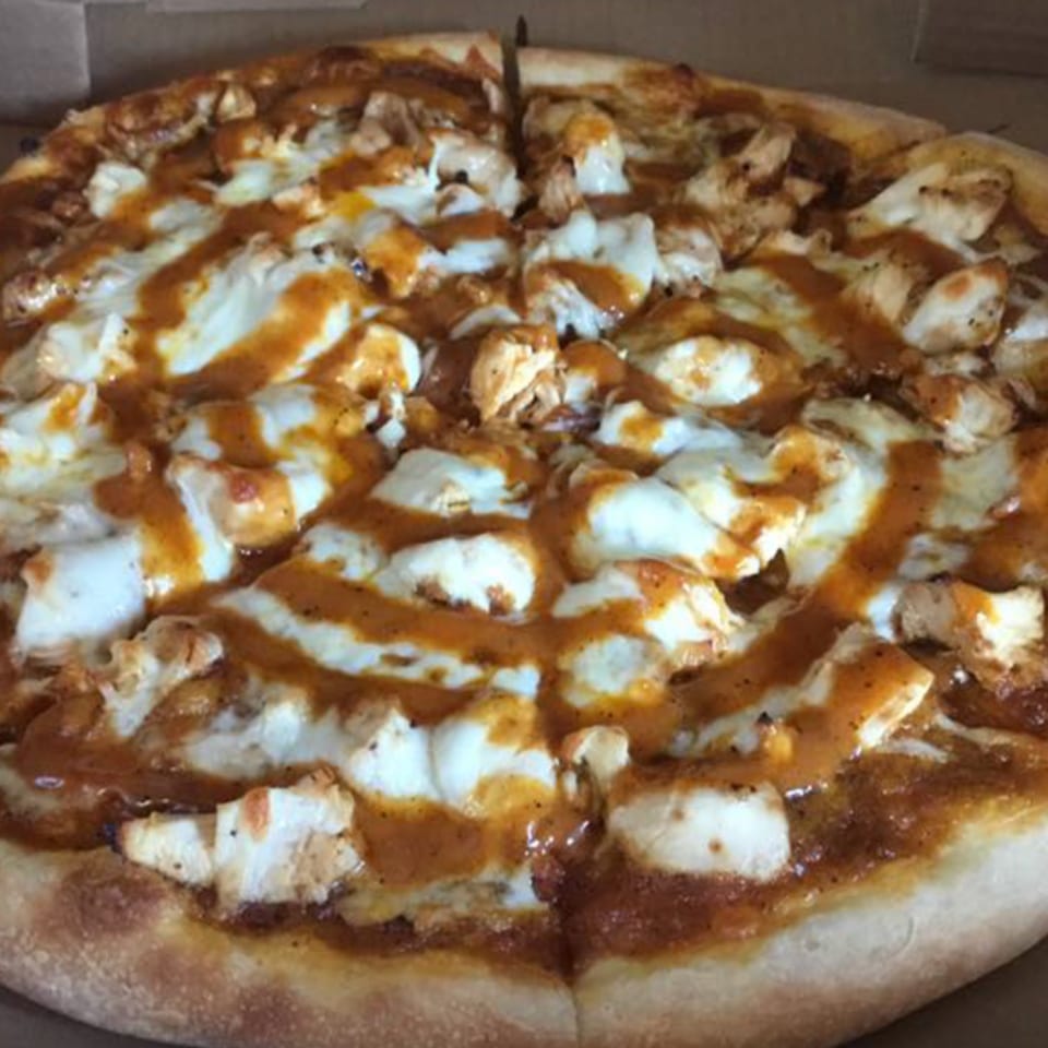 A whole BBQ chicken pizza from Vito's Bistro, topped with melted mozzarella and sauce.